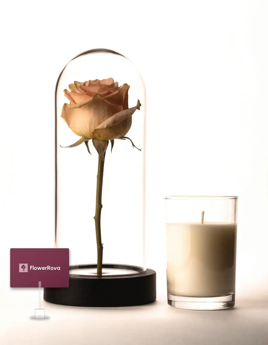 Preserved rose in a glass dome beside a scented candle, product visualisation